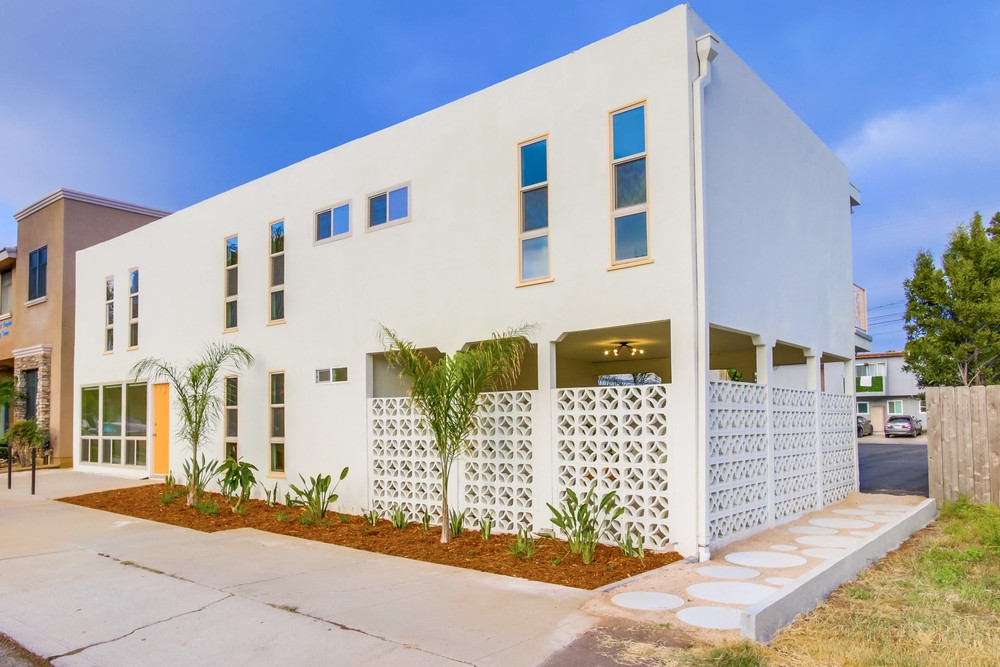 245 Church Avenue apartments in daylight, freshly remodeled with palms and bright white facade